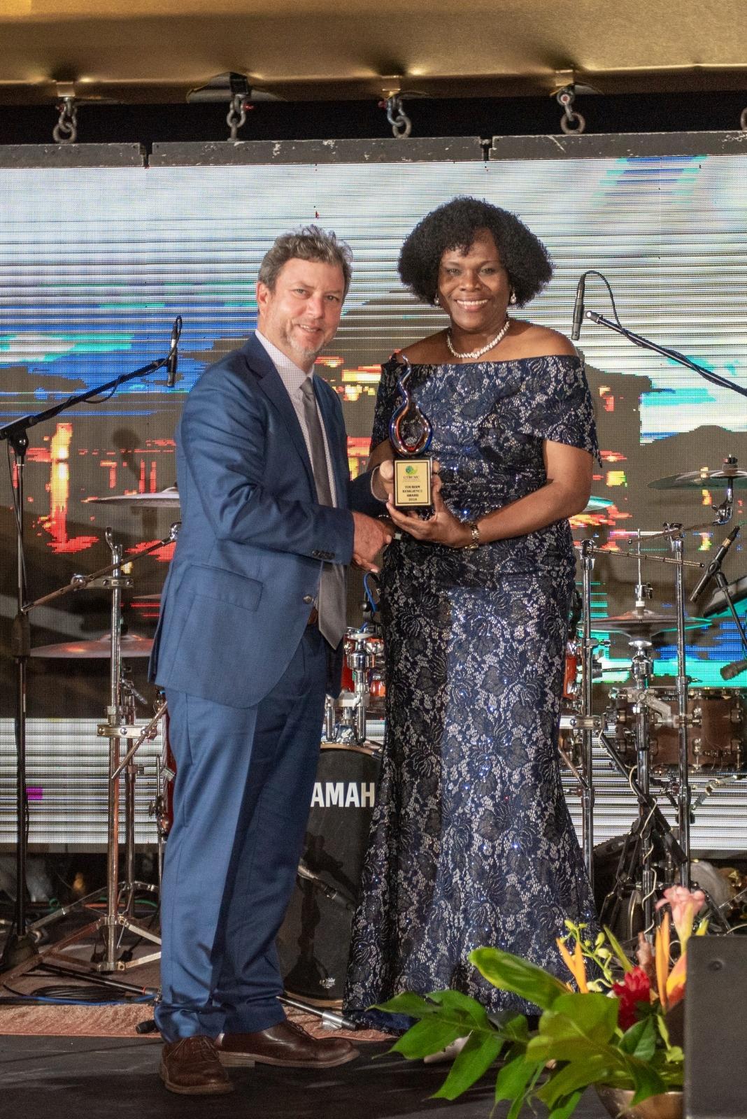 Jason Henzell (left), chairman of Jakes Hotel, Villas & Spa, the premier resort establishment in Treasure Beach, St. Elizabeth receives a Global Tourism Resilience award from Permanent Secretary in the Ministry of Tourism, Jennifer Griffith during a special awards ceremony at the Princess Grand Jamaica resort on February 18, 2025. The award was presented at a gala dinner, climaxing the 3rd Global Tourism Resilience Conference and Expo with delegates coming from as far as Africa.